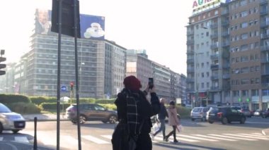 Yetişkin bir kadın akıllı telefon kullanarak fotoğraf çekiyor, sosyal, dumanlı bir konsept.