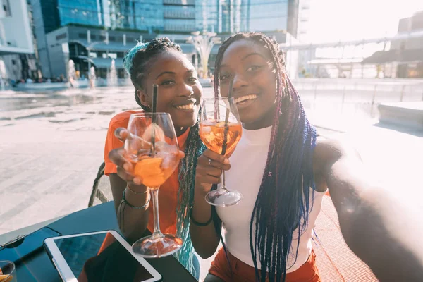 Due belle sorelle nere che tengono cocktail scattando selfie — Foto Stock