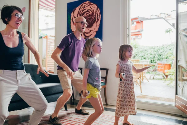 Family dancing together indoor playing videogame - healthy lifestyle, togetherness, playing concept