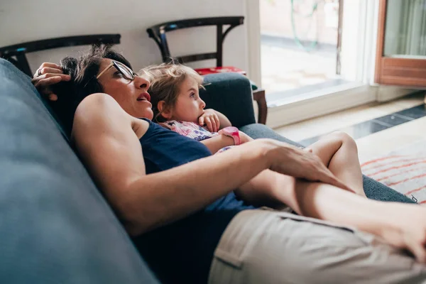 Mother with female child indoor on the couch cuddling — 스톡 사진