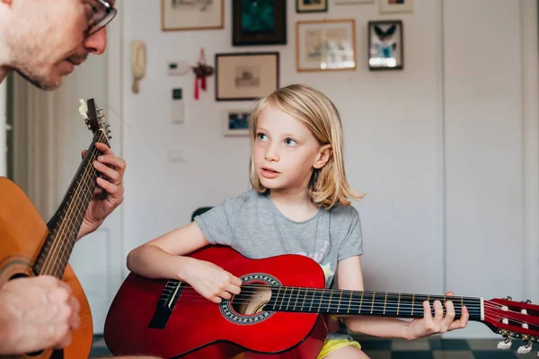 Father teaching to his daughter how to play guitar — Stock Photo, Image