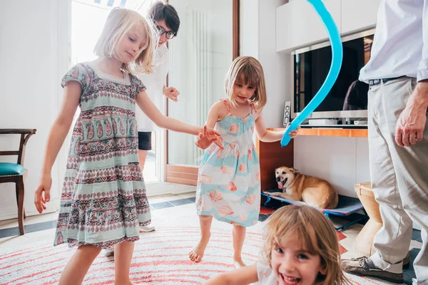 Three little sisters indoor at home playing with balloon having fun — 스톡 사진