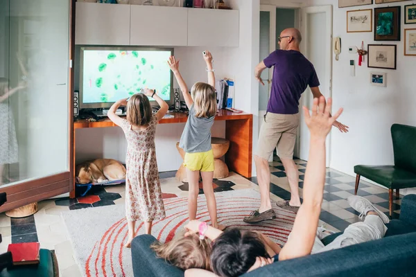 家族は屋内のビデオゲームを一緒に踊る — ストック写真