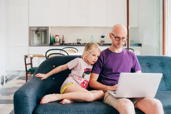 Отец смотрит мультфильм на компьютере со своей дочерью — стоковое фото