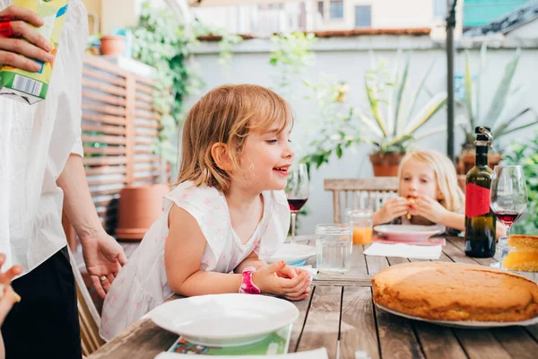 야외 식탁에 앉아 집에서 만든 케이크를 먹는 여자 아이 — 스톡 사진