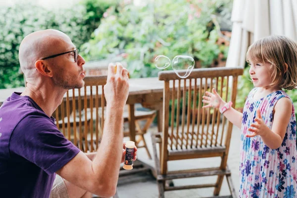 Father and female child outdoor playing bubble soap — 스톡 사진