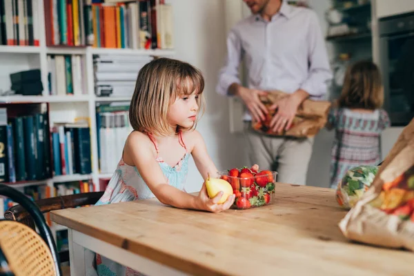 집 부엌에서 과일을 들고 있는 아름다운 여자 아기의 모습 — 스톡 사진