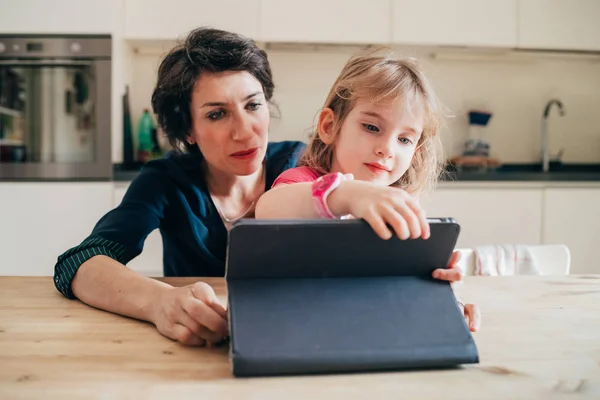 Madre e hija en interiores usando la tabla de estar de la tableta — Foto de Stock