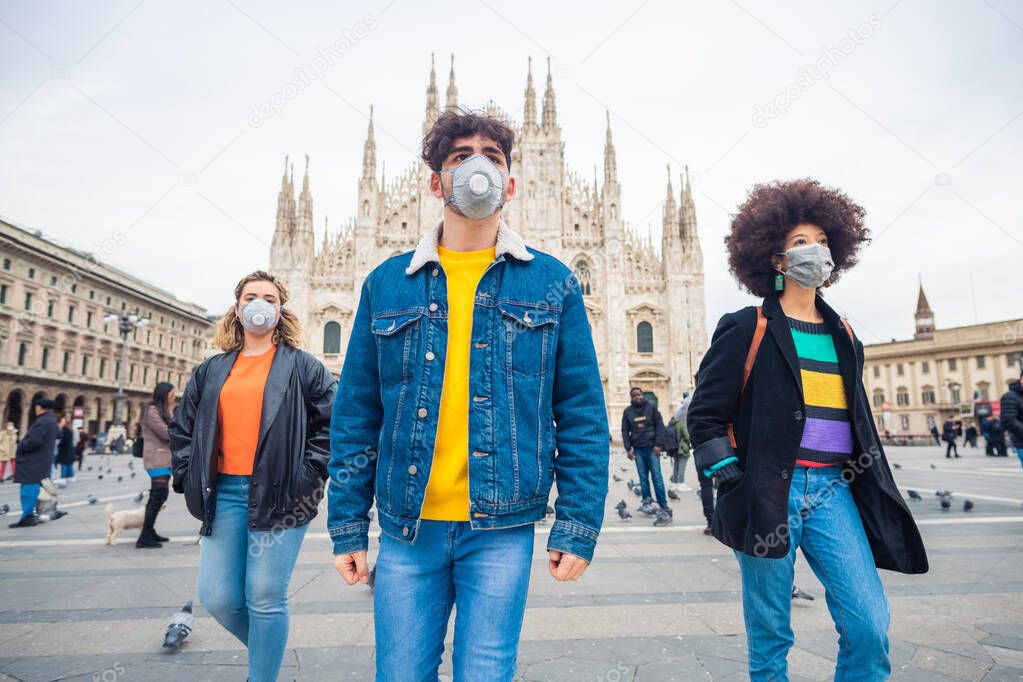Three multiethnic friends wearing medical mask protecting from pollution and virus - anti-smog, infection, protester concept
