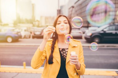 Genç ve güzel bir kadın köpüklü sabun oynuyor. Genç, pozitif, rüya gibi bir konsept.