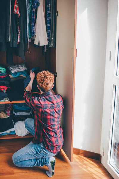 Young woman indoor at home cleaning closet - spending time, organization, housework concept