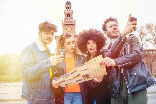 Dört kişilik grup, gezgin arkadaşlarıyla açık hava haritası ve akıllı telefon araması yapıyor. Gezmek, keşfetmek, tatil konsepti.