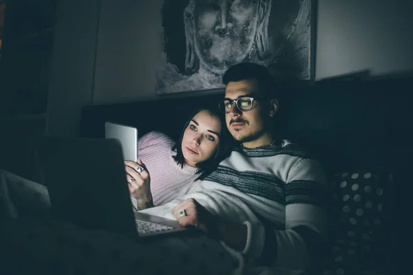 Pasangan Muda Kaukasia Berbaring Dalam Rumah Menggunakan Tablet Dan Komputer — Stok Foto