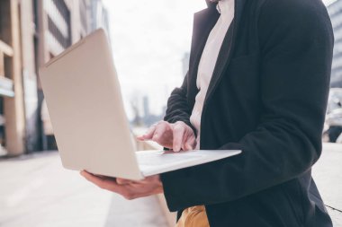 Orta bölüm adamı dışarıda bilgisayar kullanıyor - serbest çalışan, yayın, alışveriş konsepti