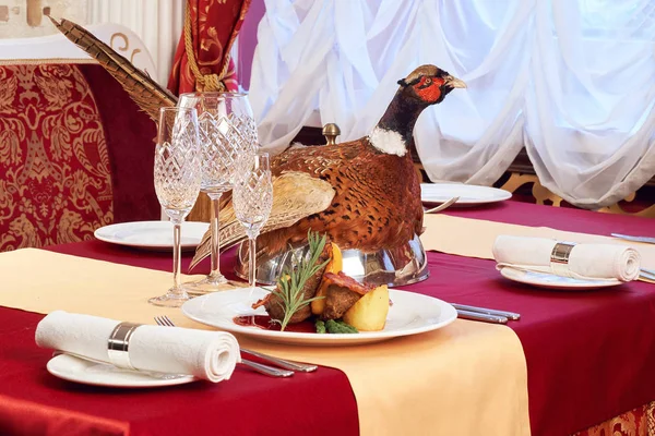 Decorated table with meat . The Cloche with bird pheasant on top — Stock Photo, Image