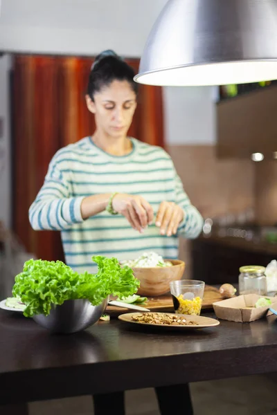Современная девушка готовит смешанный салат на кухне Лицензионные Стоковые Изображения
