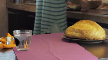 Genç bayan domates ve peynirle yapılan masaya vejetaryen tostu getiriyor.