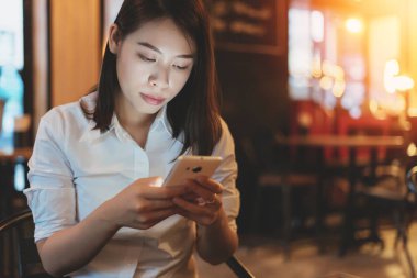 Akıllı telefon kullanan genç kadın görüntüsünü seyir Instagram.