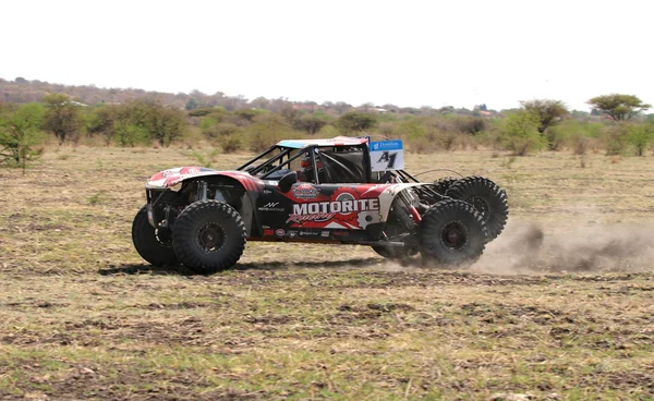 Side view of Speeding white and red Bat Spec 5 rally car — Stockfoto