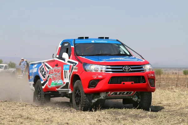 Närbild av fortkörning röda och blå Toyota Hilux single cab r — Stockfoto