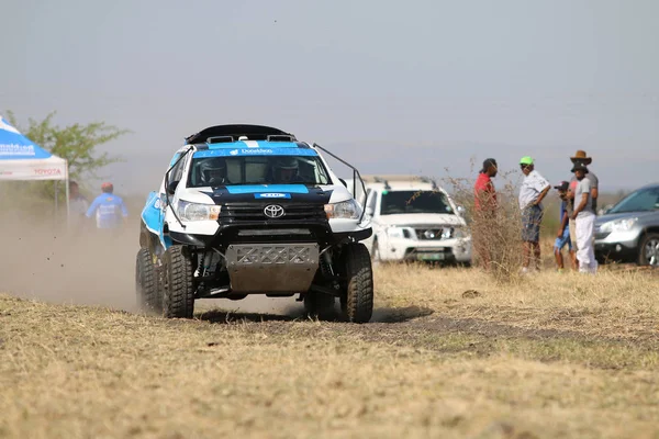 Speeding white and blue Toyota Hilux twin cab rally car front vi — Stock Photo, Image