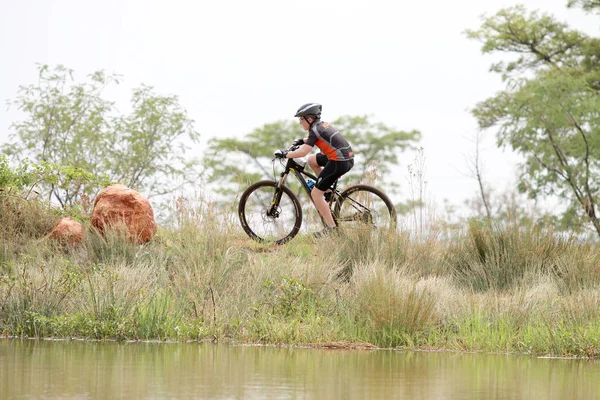 Young boy riding on edge of dam at Mountain Bike Race — Stock Photo, Image