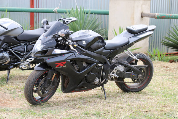 Parked black Suzuki GSXR 1000 cc motorbike on green grass