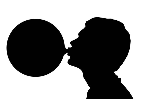 Silhouette of teenage boy blowing huge bubble 