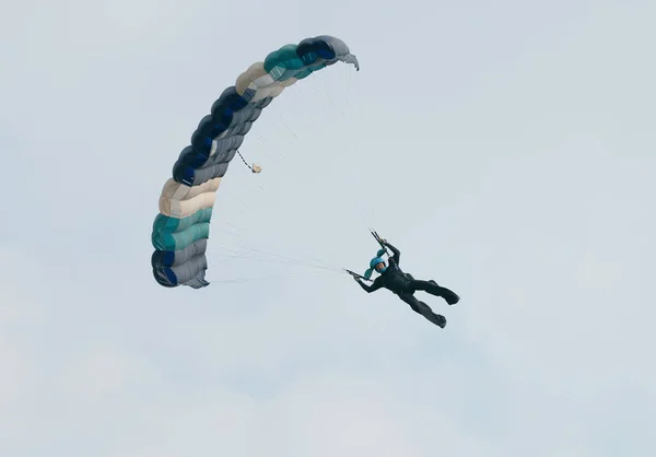 Buzo de cielo masculino con paracaídas abiertos de colores brillantes deslizándose en — Foto de Stock