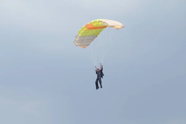 Buzo de cielo masculino con paracaídas abiertos de colores brillantes deslizándose en — Foto de Stock