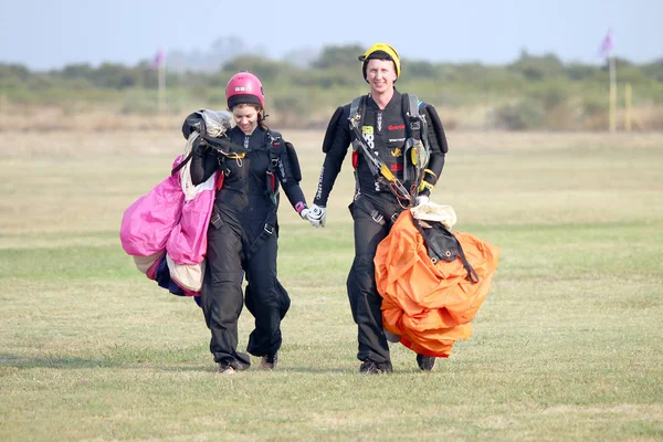 Det är kärlek i luften! Man och kvinna fallskärmshoppare promenader hand i hand — Stockfoto
