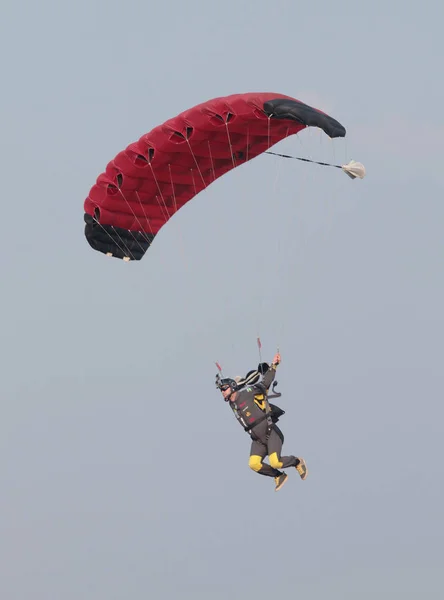 Mergulhador de céu masculino com pára-quedas aberto colorido brilhante deslizando em — Fotografia de Stock