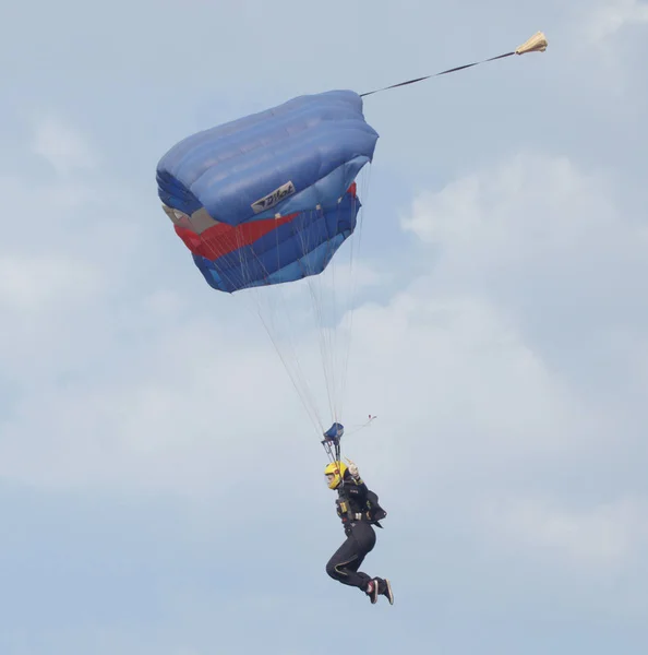女性天空潜水员与鲜艳的降落伞打开着陆 — 图库照片