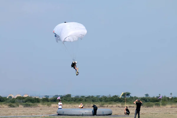 Jumper com paraquedas brancos abertos realizando clássico precisão lan — Fotografia de Stock