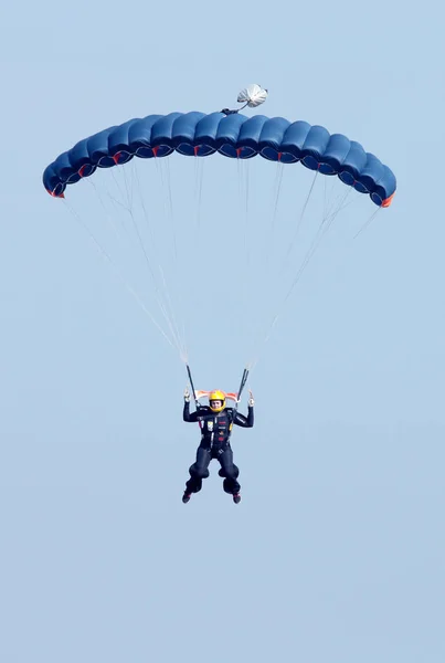 Nurek niebo kobiece z jasny niebieski otwarty spadochron — Zdjęcie stockowe
