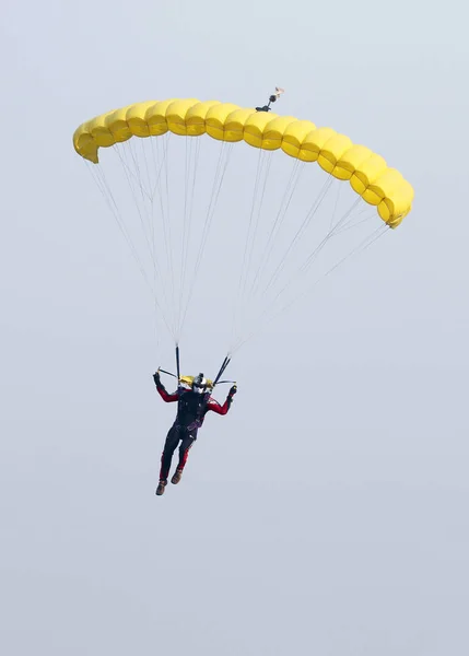 Male sky diver with brightly coloured open parachute gliding in — Stock Photo, Image