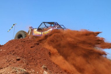 Araba çaprazlanarak dik tepeye, kum ve taşları tekme.