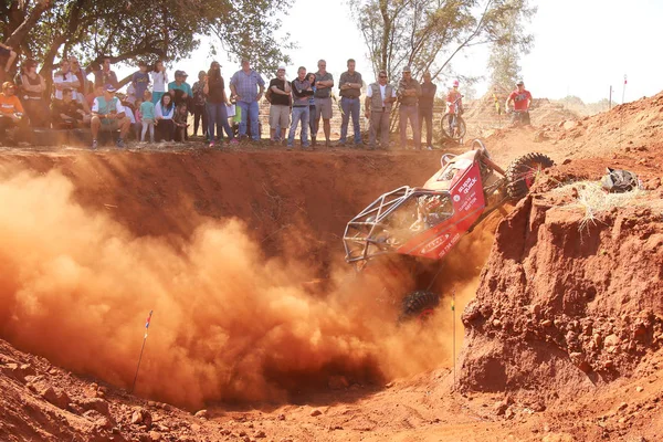 Red Car climbing out steep dugout, kicking up sand and dust — Stock Photo, Image