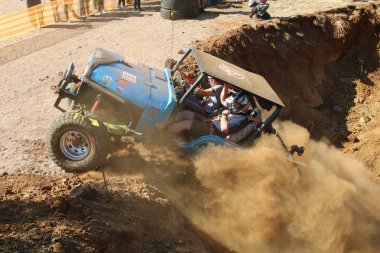 Seyircilerin sığınağın dışında mavi araba güç izliyor