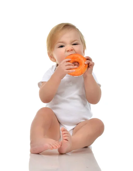 Nyfödda barn baby boy småbarn äter söt donut godis snabbmat — Stockfoto