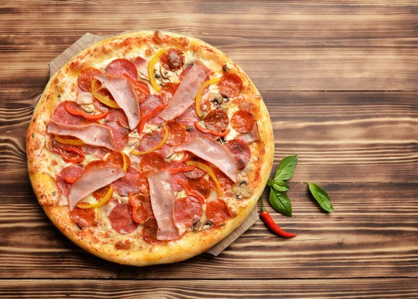 Pizza sabrosa entera grande caliente con jamón de tomates de tocino de queso derretido — Foto de Stock