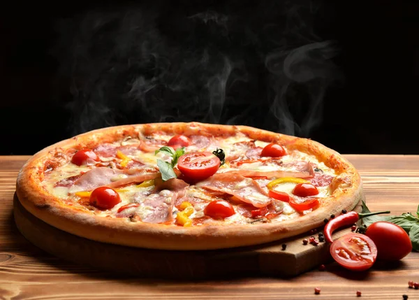 Pizza sabrosa entera grande caliente con jamón de tomates de tocino de queso derretido — Foto de Stock