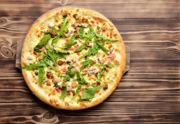 Hot big whole tasty pizza with melting cheese bacon tomatoes ham — Stock Photo, Image
