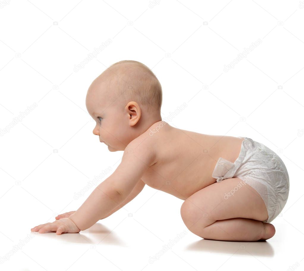 Infant child baby girl learning how to crawl in diaper looking a