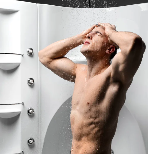 Strong body man taking shower in new bathroom with hydro massage — Stock Photo, Image