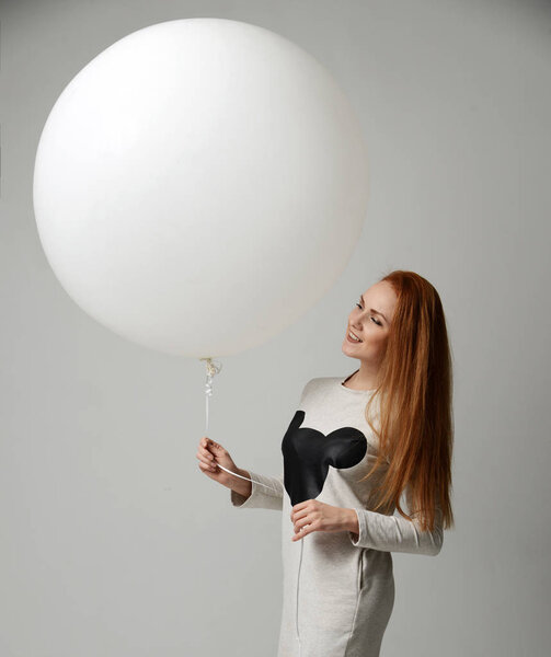 Young happy girl with huge big white balloon as a present for bi