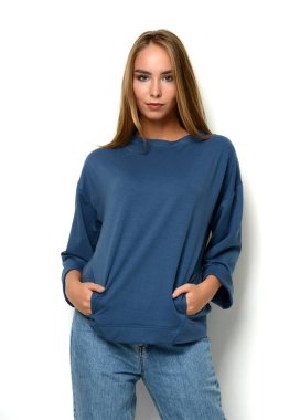 Genç mutlu güzel kadın yeni moda mavi kot pantolon ve kazak poz 