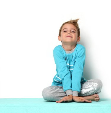 Düşünme ve ararken mavi kazaklı oturan mutlu genç çocuk