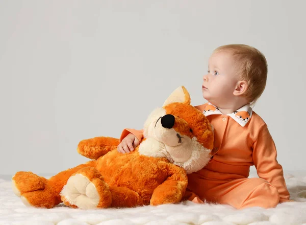 Infant child baby kid toddler sitting with soft fox toy and looking at the corner — Stock Photo, Image