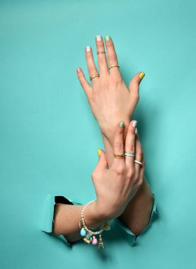 Sarı Pembe Beyaz desen tırnak cilası ile güzel kadın el 